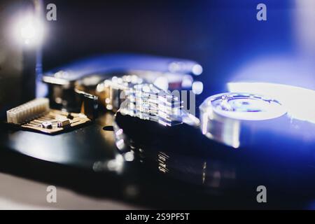 Close-up of hard drive components under blue lighting, emphasizing its intricate circuitry Stock Photo