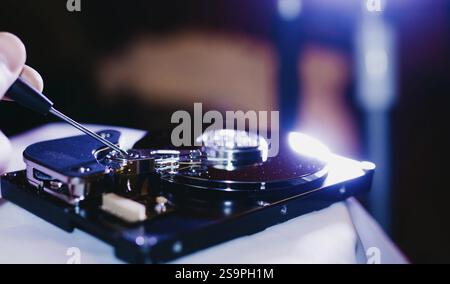 An open hard drive being repaired with a screwdriver Stock Photo