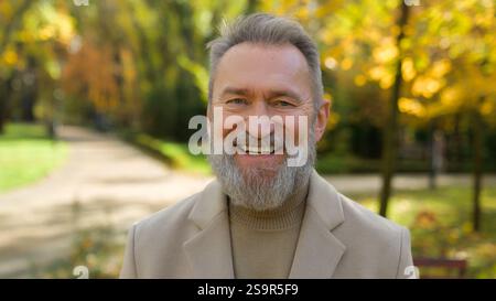 Outdoor male portrait happy joyful cheerful 60s old mature senior middle aged Caucasian man retired businessman looking camera smile single Stock Photo