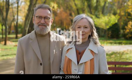 Happy family Caucasian middle-aged couple love in autumn park retired 60s man woman cheerful smile smiling in city outdoors two grandparents senior Stock Photo