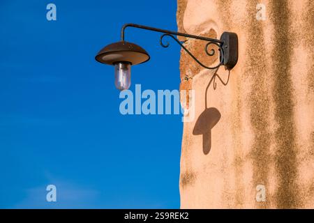 Modern LED lamp on the facade of an old house in Tratalias Vecchio. Stock Photo