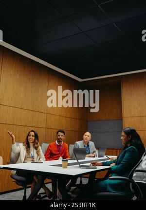 A diverse group of professionals is engaged in a collaborative business meeting, illustrating the importance of diversity, teamwork, and productivity Stock Photo