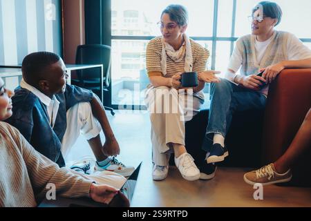 Teacher talking with students in a casual setting, fostering communication and engagement during a relaxed group discussion in a contemporary classroo Stock Photo