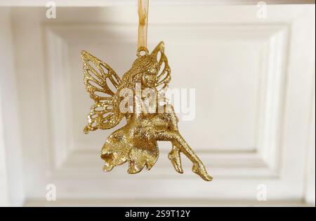 Christmas tree decoration in the form of a petite golden glittering fairy Stock Photo