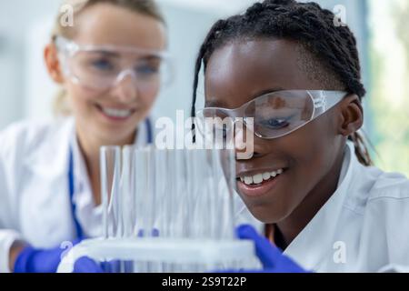 Women researchers conducting experiment on dna samples using tubes with liquid in laboratory Stock Photo