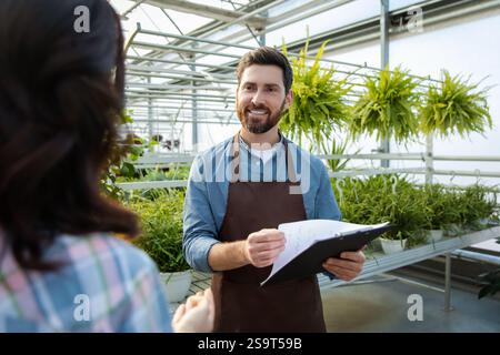 Two professionals talking in the greenhouse discussing plant cultivation Stock Photo