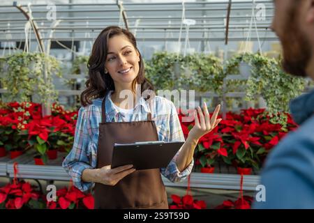 Two professionals talking in the greenhouse discussing plant cultivation Stock Photo