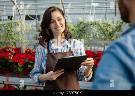 Two professionals talking in the greenhouse discussing plant cultivation Stock Photo