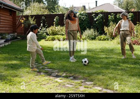 Playing Soccer Outdoor in Green Backyard Setting Stock Photo