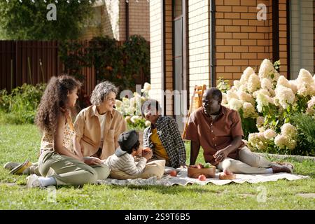 Enjoying Picnic Outdoors With Family Under Sunlight Stock Photo