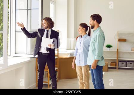 Happy young family couple are visiting potential new house with real estate agent Stock Photo
