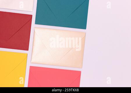 Multicolored envelopes neatly laid out on a blue background. Creative business concept with copy space. Stock Photo