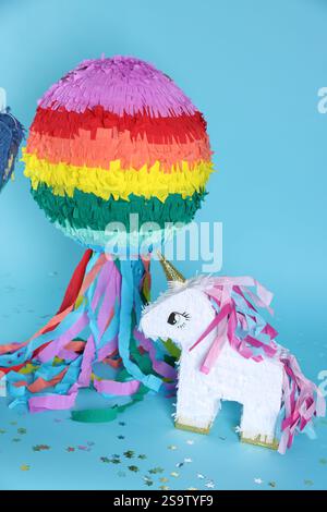 Bright colorful pinatas and confetti on light blue background Stock Photo