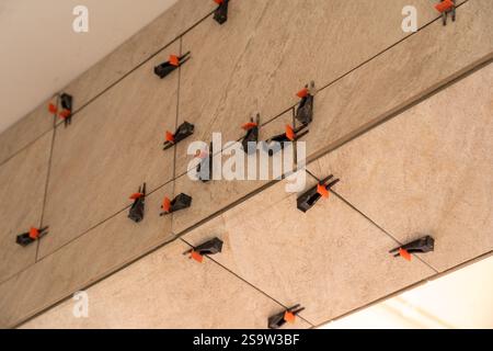Tile leveling system with plastic clips and wedges, shot while the tile mortar sets. Wall tiling. Stock Photo