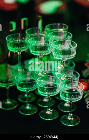 A pyramid of wide champagne glasses on deep blue tablecloth at event Stock Photo