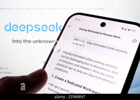 DeepSeek AI chat example seen on the smartphone with the question about motivation and company webside is seen on the blurred background. Stafford, Un Stock Photo