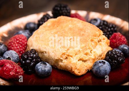 Homemade biscuit on plate with fresh raspberries, blueberries, and blackberries Stock Photo