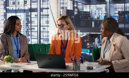 Multicultural group of women in a high powered office meeting, promoting gender equality and female authority in a work environment. Leaders in a men dominated business industry. Camera A. Stock Photo