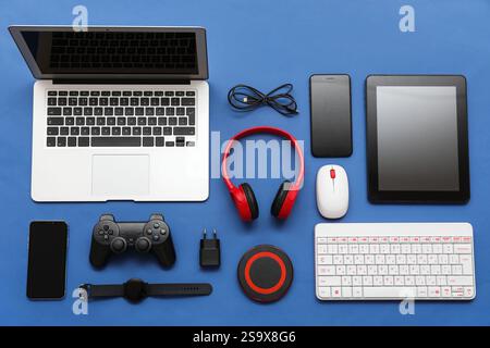 Composition with different modern gadgets on blue background Stock Photo