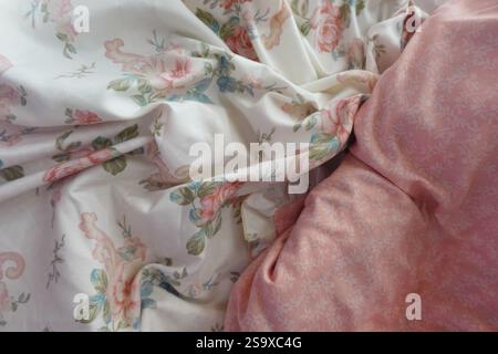 Soft floral bedding with pink accents on a cozy bed Stock Photo