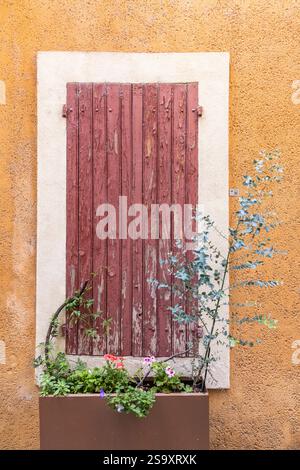 L'Isle-sur-la-Sorgue, Avignon, Vaucluse, Provence-Alpes-Cote d'Azur, France. Red peeling paint on wooden window shutters. Stock Photo