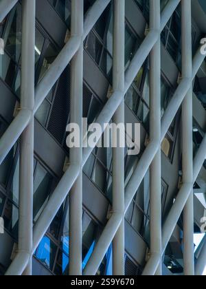 Close-up detail of a Hong Kong building's geometric facade.  The intricate steel framework and window pattern create a striking visual texture. Stock Photo