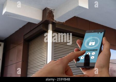 Cropped image of female entering secret key code for getting access and passing building using application on mobile phone, woman pressing buttons on Stock Photo