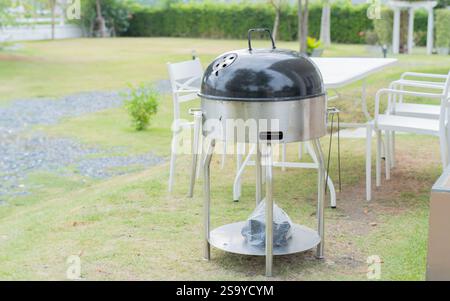 Scene of family barbecue grill party or picnic on the lawn in the backyard at summertime weekend. Selective focus. Stock Photo