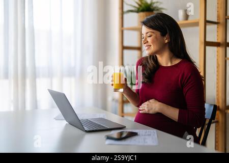 Young pregnant business woman, online teacher looking at laptop, online remote video call concept Stock Photo