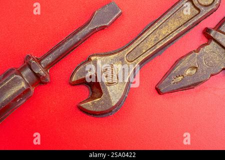 Old rusty pliers isolated on a red background. Stock Photo
