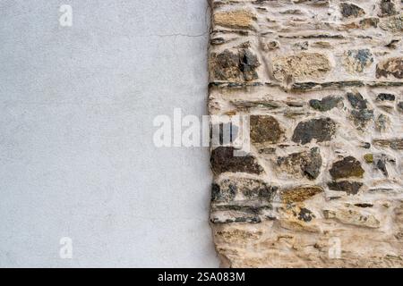 old nature stone wall against white modern textured plaster contrast background Stock Photo