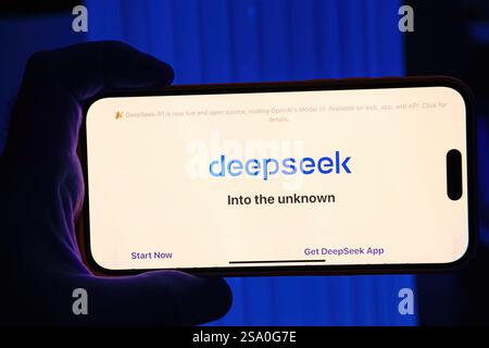 Paris, France - Jan 28, 2025: Smartphone screen displaying the DeepSeek-R1 introduction, showcasing its tagline Into the unknown and app options, held Stock Photo