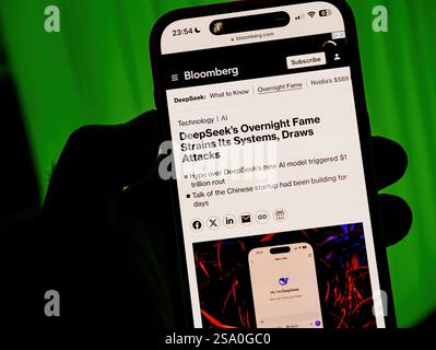 Paris, France - Jan 28, 2025: Smartphone screen displaying Bloomberg's article about DeepSeek's sudden fame straining its systems and drawing cyberatt Stock Photo