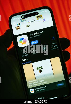 Smartphone screen displaying the Microsoft Copilot app page in the App Store. Ranked number 24 in productivity, featuring an update option and app det Stock Photo