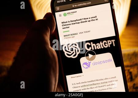 Smartphone screen displaying USA Today's article on DeepSeek, a small Chinese AI startup, disrupting the AI sector on Warm-lit background emphasizes t Stock Photo
