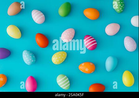 Colorful pattern composition made of various colored Easter eggs on light blue background. Minimal Easter concept. Stock Photo