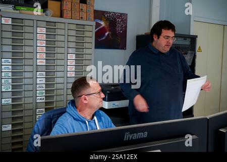 Disabled worker and his monitor working in the printing, reprography and marking workshop. Stock Photo