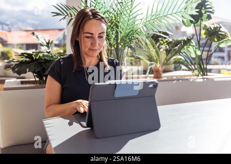 A woman is working using her tablet in the office, photo with copy space. Stock Photo