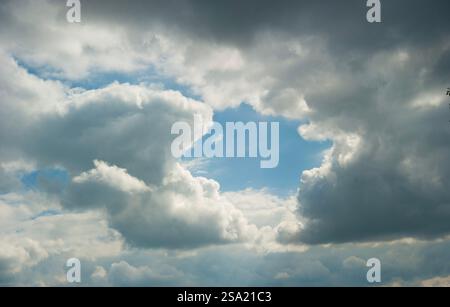 clouds covering the sky with a hole showing the blue sky behind Stock Photo
