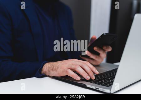Cropped image of businessman using mobile phone while sitting at desk in office Stock Photo