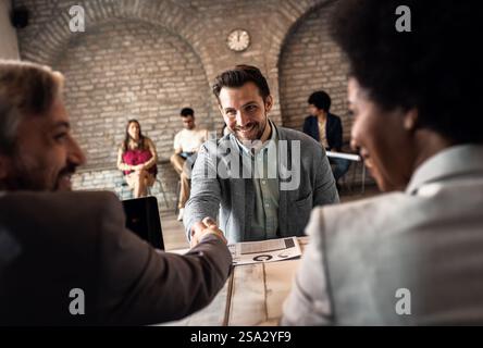 Business recruiters shakes hands with candidate during job interview. Stock Photo