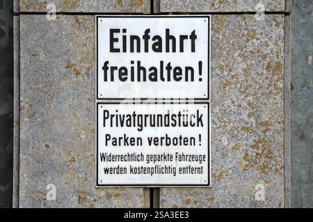 Stuttgart, Baden-Württemberg, Germany - January 23, 2025: Sign with the inscription: Privatgrundstück - Parken verboten on a wall in Stuttgart. The sign warns that illegally parked vehicles must be removed for a fee *** Schild mit der Aufschrift: Privatgrundstück Parken verboten an einer Wand in Stuttgart. Das Schild warnt davor, widerrechtlich abgestellte Fahrzeuge kostenpflichtig zu entfernen Stock Photo