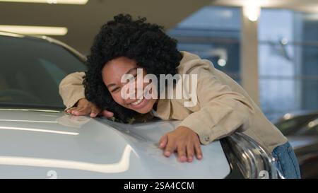 Happy customer client African American woman businesswoman girl buying new car enjoy luxury purchase in auto dealership female owner buy rent vehicle Stock Photo