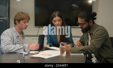 Business partners colleagues female woman leader male men employees at office boardroom talking discuss project plan analyzing corporate documents Stock Photo
