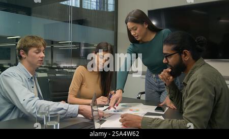 Team leader coworkers planning work analyzing corporate documents reviewing statistics learn data charts graphs group diverse businessmen Stock Photo