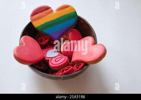 Red and white cookies hearts, hanging on natural thread over the brown wooden background. Wooden plate. Valentine's Day.Valentine day background.Copy Stock Photo