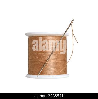 A spool with brown orange color sewing thread with a needle isolated cutout on white Stock Photo
