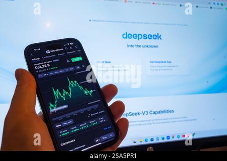 Analyzing stock trends on a smartphone while using a computer for insights Stock Photo