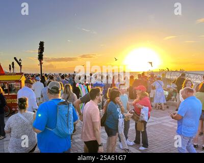 Key West, Florida, USA - December 28, 2022: Hundreds of tourists gather nightly at Mallory Square in Key West, Florida to watch the brilliant sunset. Stock Photo