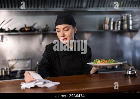 Woman cook checks paid check and cooked dish in kitchen Stock Photo - Alamy